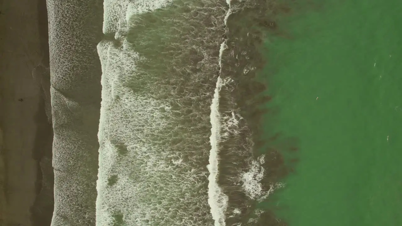 Stunning aerial of green sea waters and waves crashing in Costa Rica