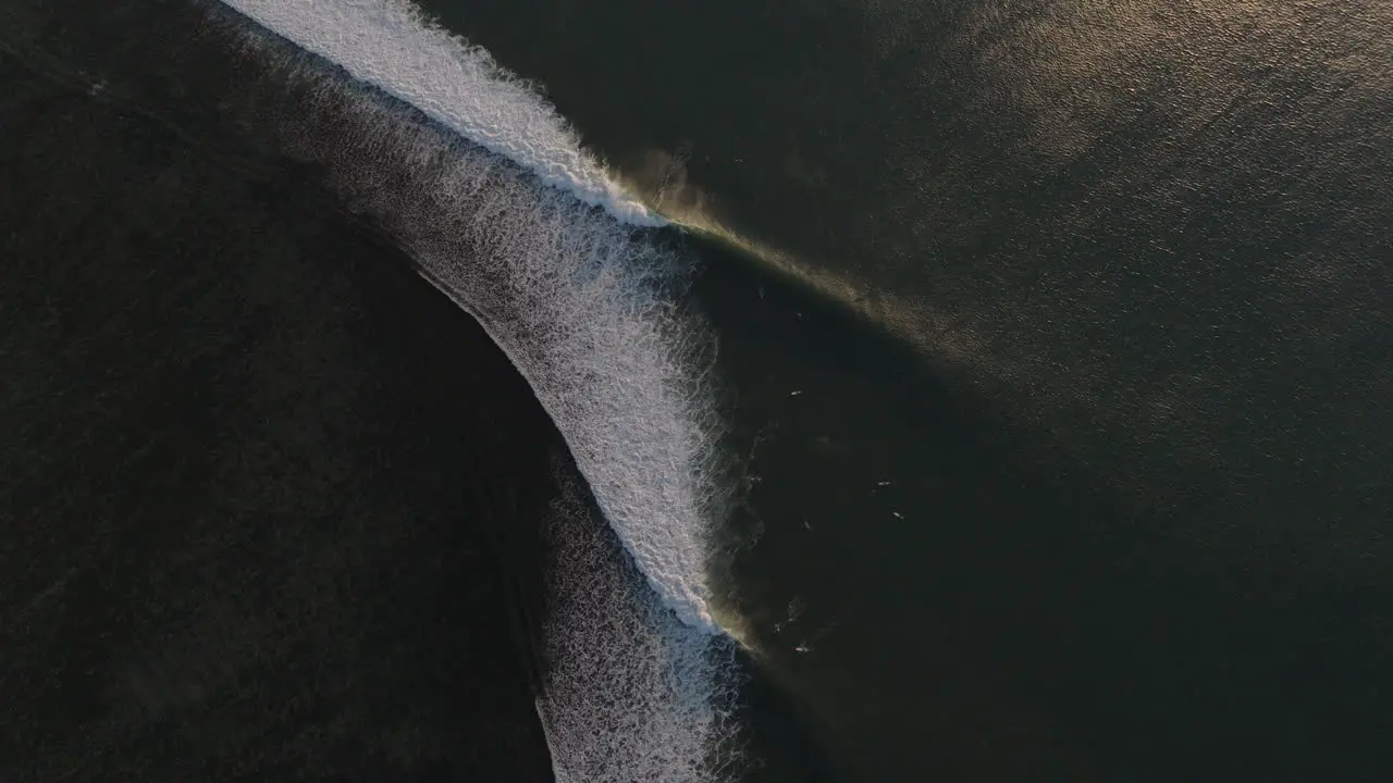 Mesmerizing aerial view of surfer on perfect reef break at sunset