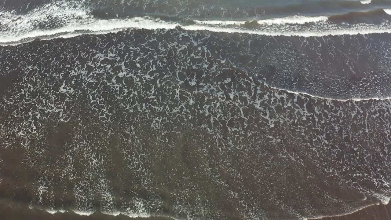  Top Down View Of Waves Rolling Over The Beach aerial drone shot