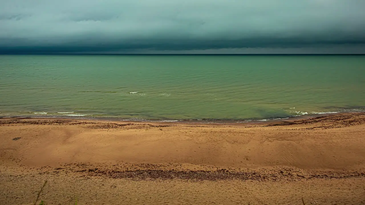 Timelapse shot of dark cloud moving over sea shore with waves crashing on a rainy day