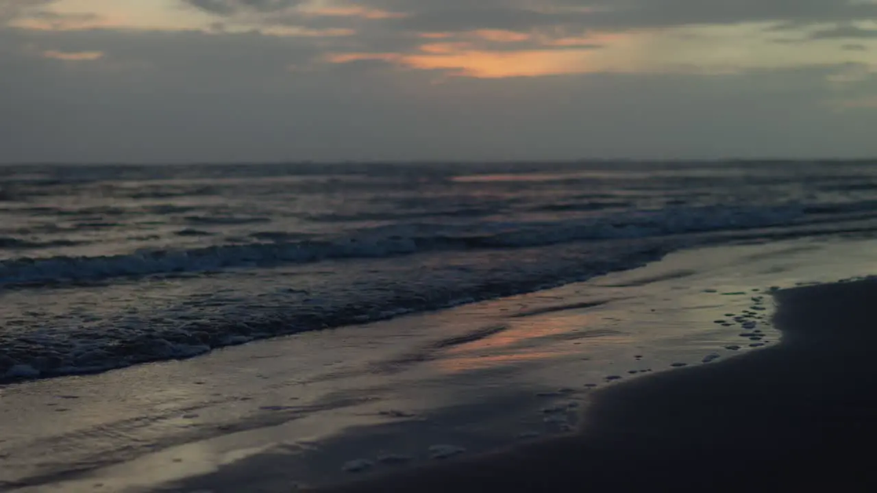 Serene shot of rhythmic waves ron golden sands of the beach during golden hour