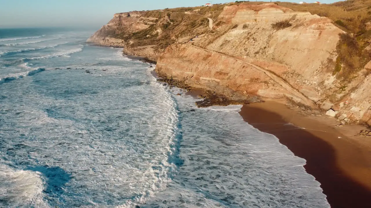 Aerial of relentless sea waves crashing at rugged coastal area of Portugal