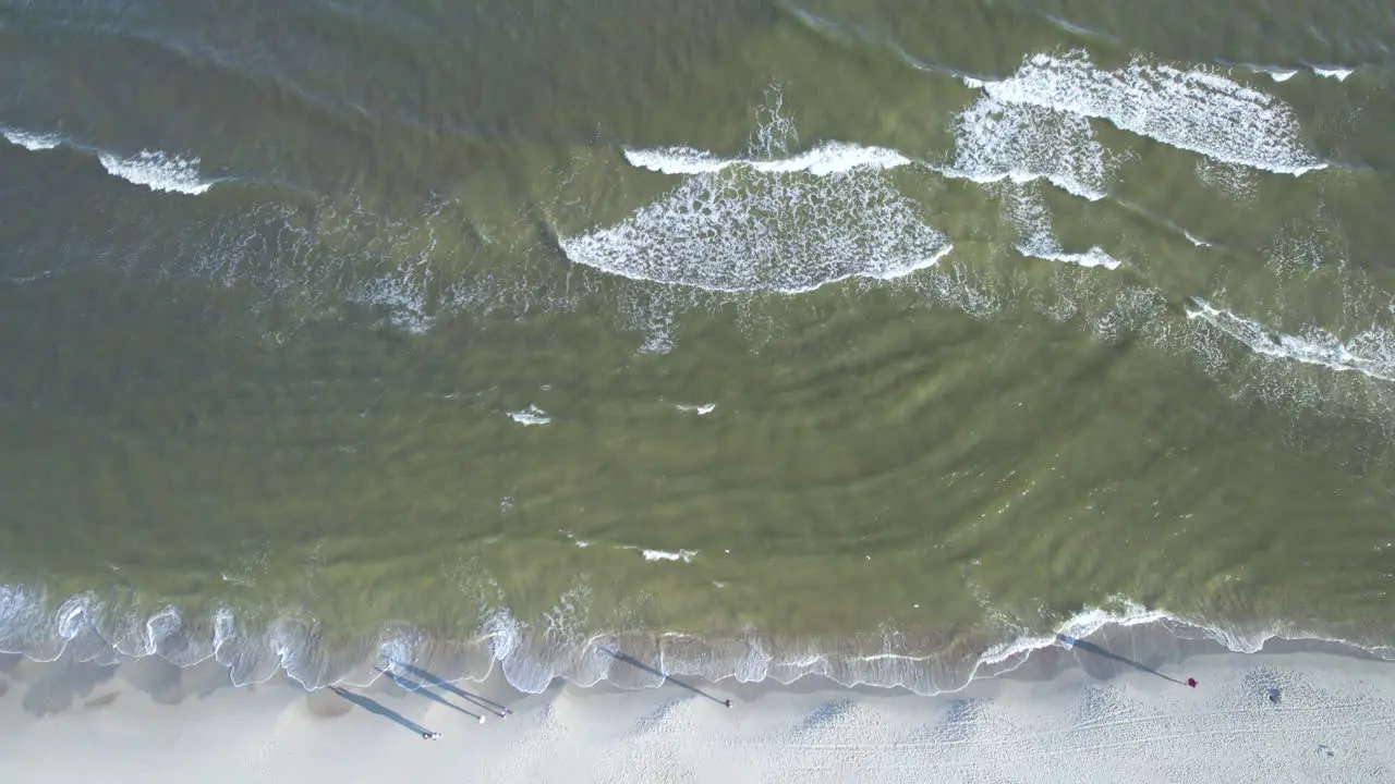 Aerial Birds Eye View Over Waves Gently Breaking On Beach At Krynica Morska