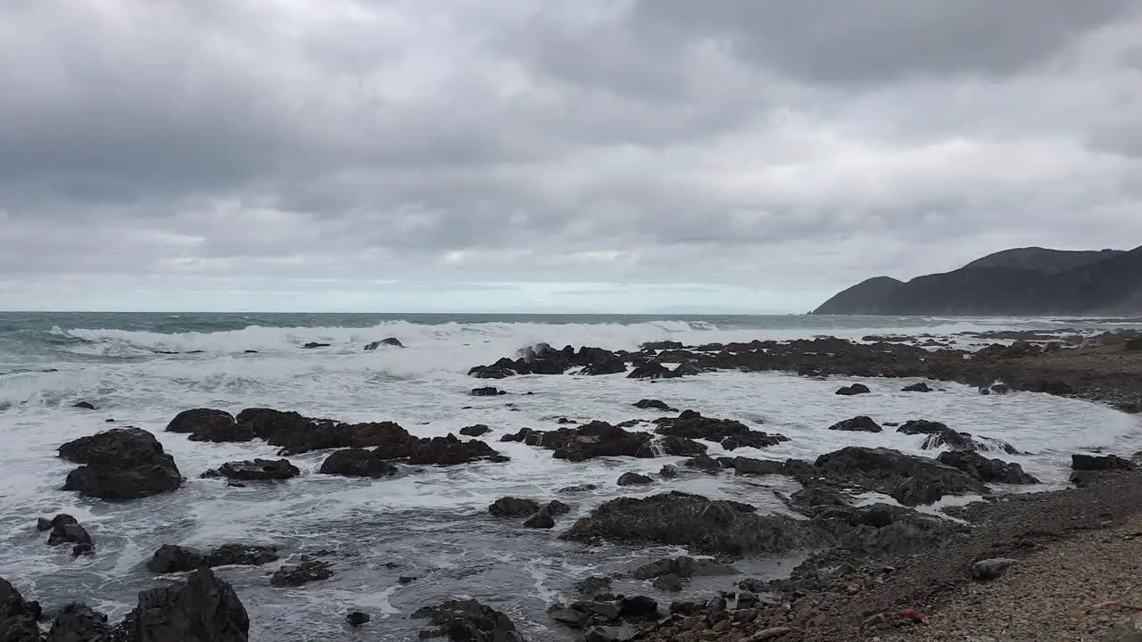 Wild white wash waves crashing over rocks along beautiful rugged remote coastline in Wellington New Zealand Aotearoa