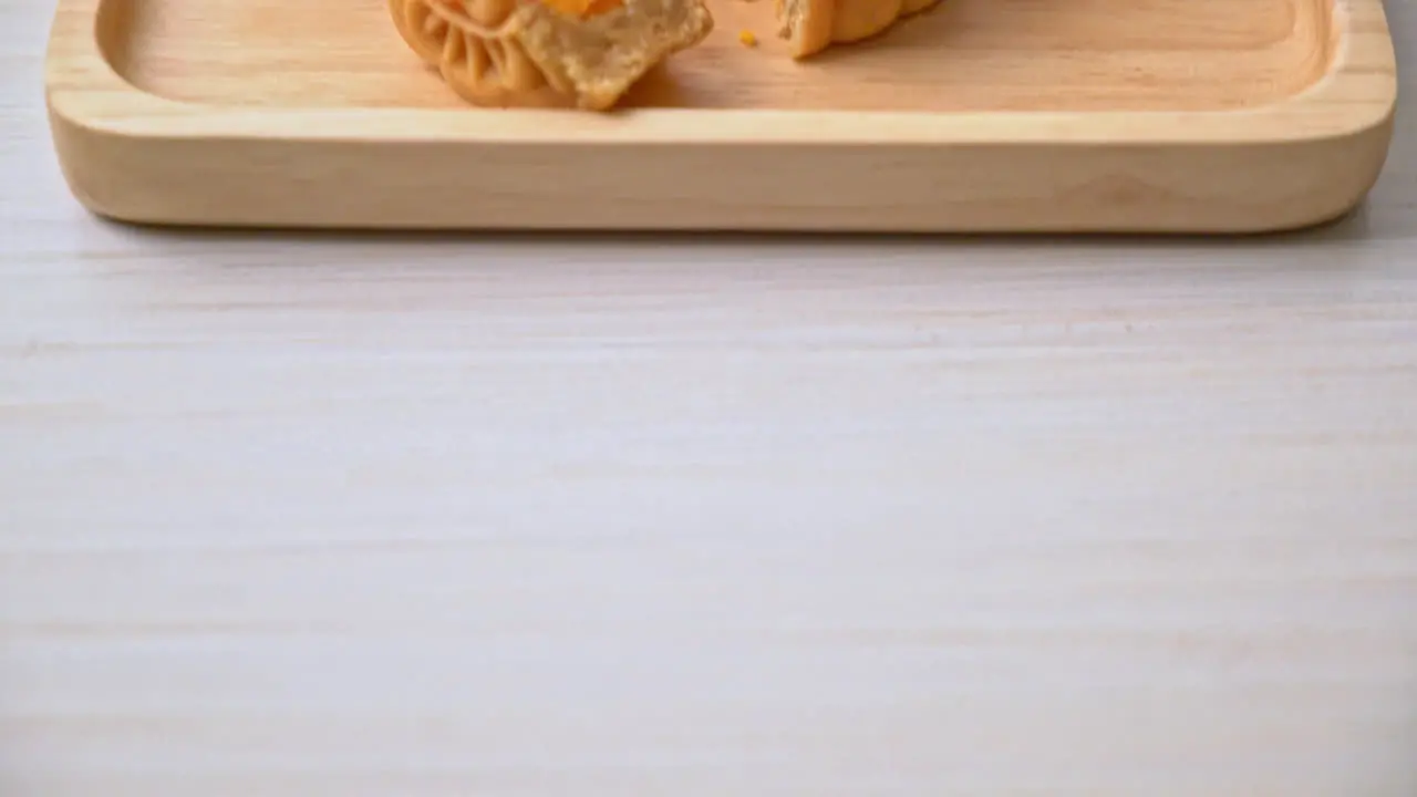 Chinese moon cake durian and egg yolk flavour with tea on wood plate