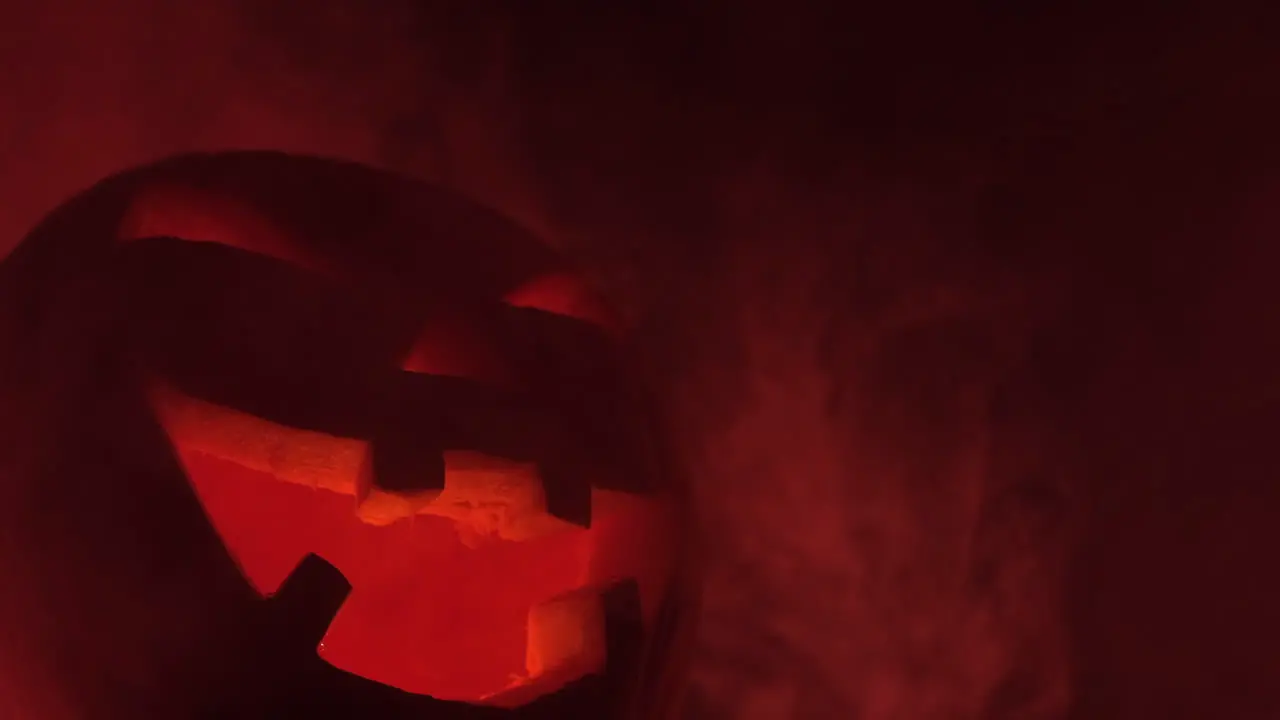 Halloween grinning pumpkin in horror dark scary red background mist