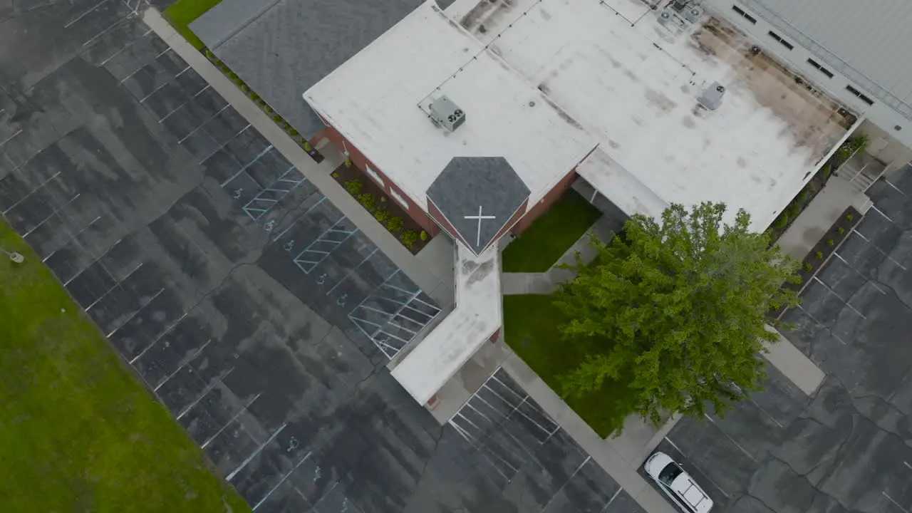 High angle approach to a red brick church on a foggy day