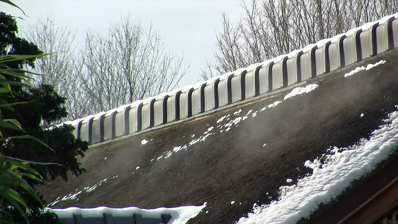 Roof of Japanese house emits mist from melting snow