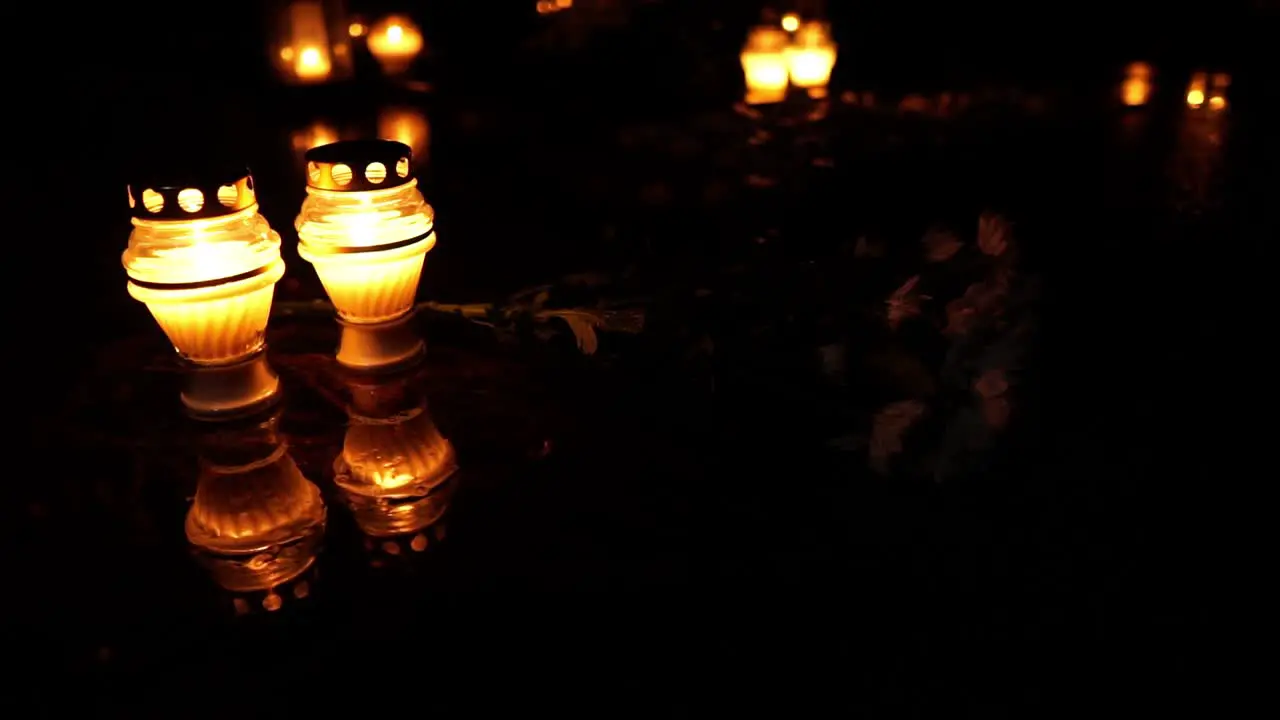 Cemetery grave burning candle at all souls day dark night and spooky atmosphere rip