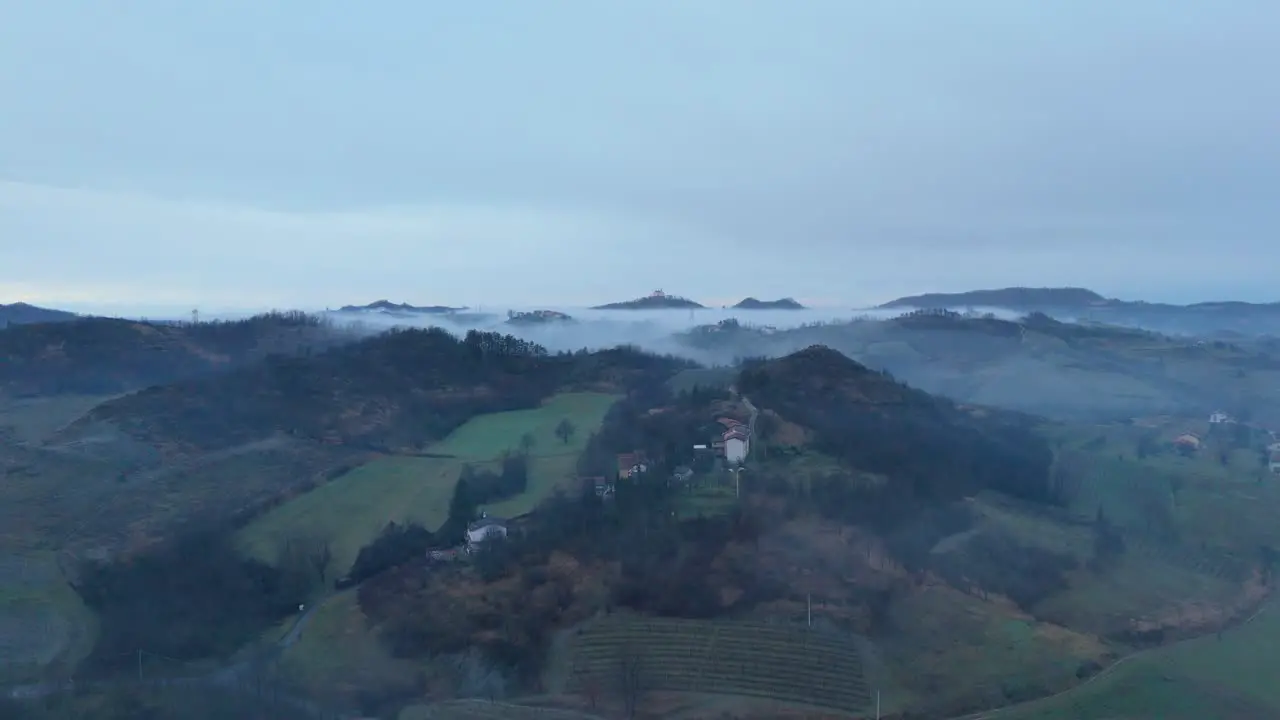 Mist over village countryside at early morning below overcast sky