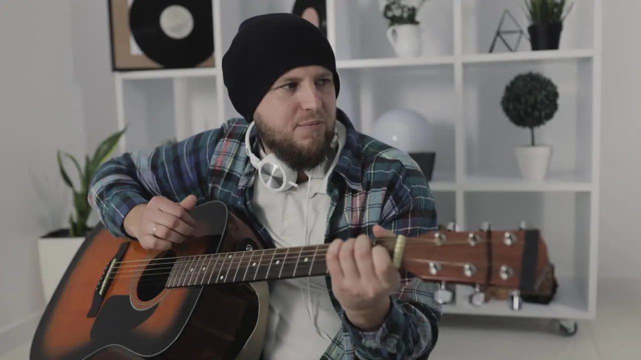 Male Urban Musician Singing And Playing Guitar At Home 1