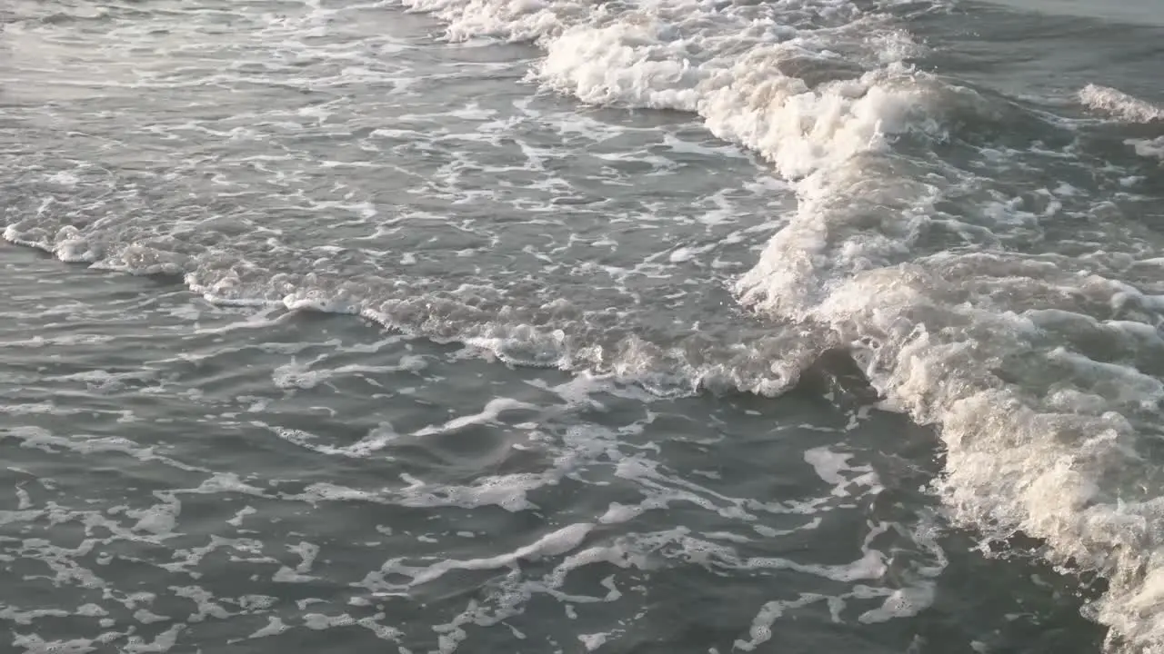 waves of sea water that wash the beach sand in the afternoon