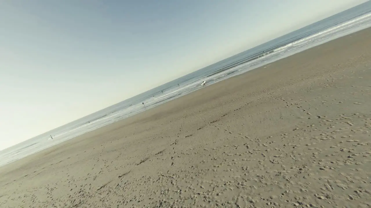 Fast aerial shot of a beach in Domburg with people surfing