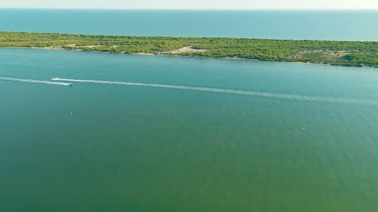 Arial view of People Riding or Driving Hydrocycles near Playa Flecha Nueva Umbria Spit Separating Piedras River from Atlantic Ocean daytime on sunny day Huelva Andalusia Spain