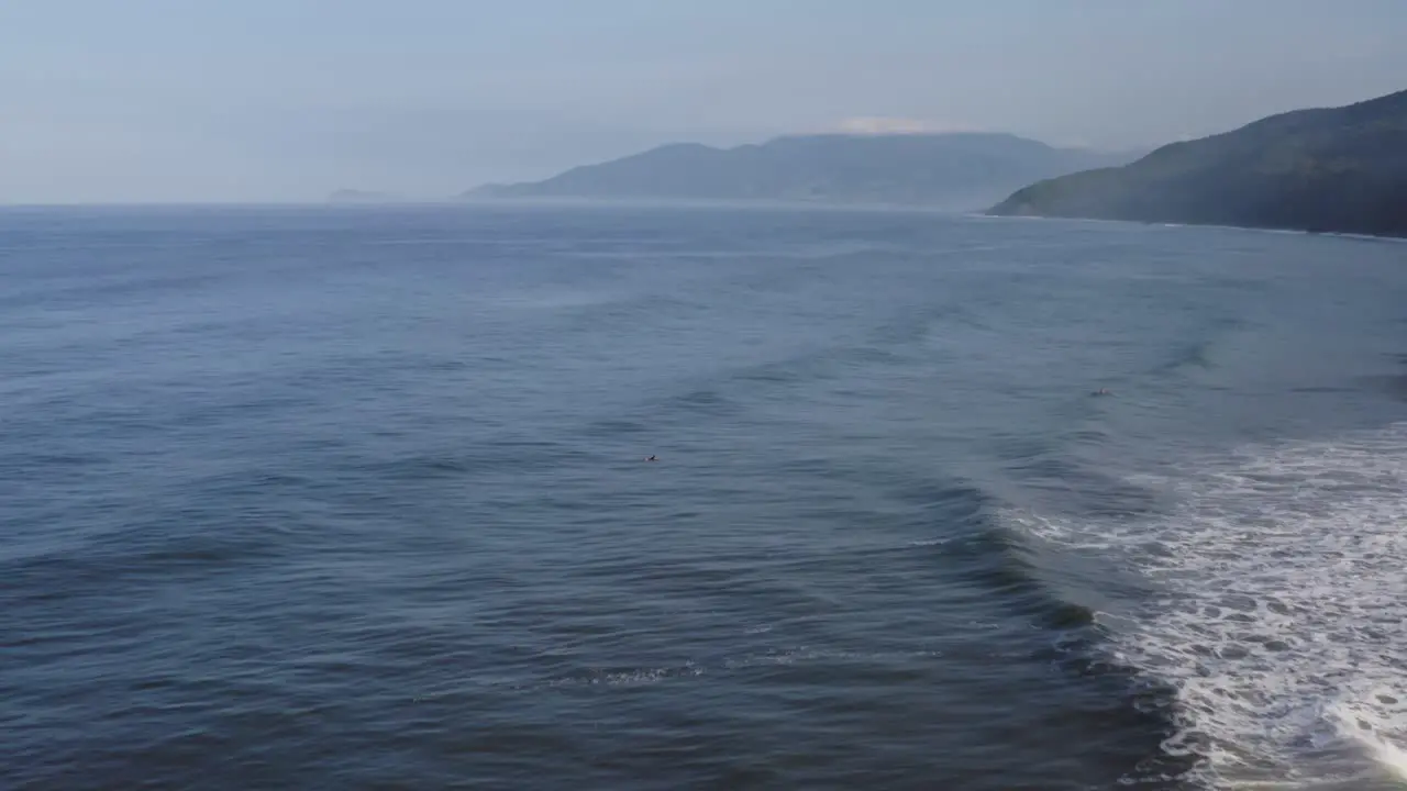 Aerial male surfers relaxing on surfboards behind breaking waves Mexico