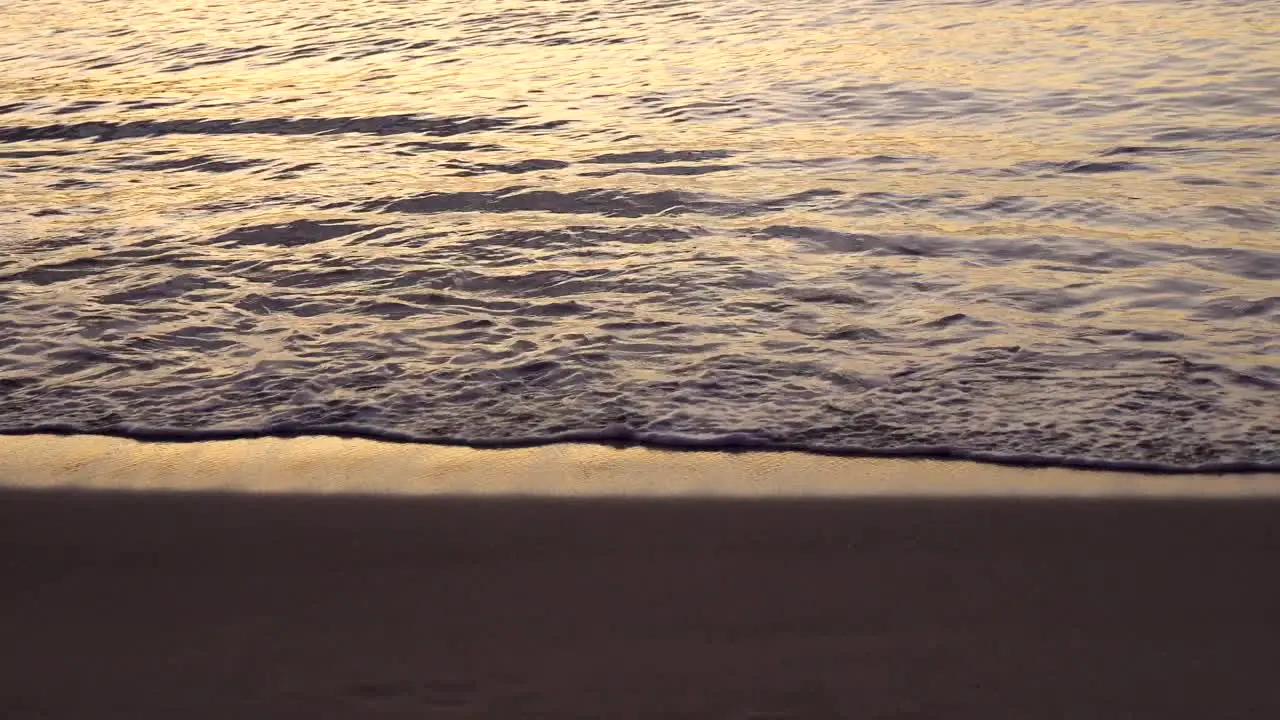 Close up of waves washing ashore tropical Hawaiian beach at sunset