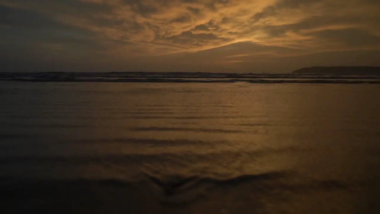 Seascape view of ocean waves crashing on the coastline at sunset on a cloudy evening