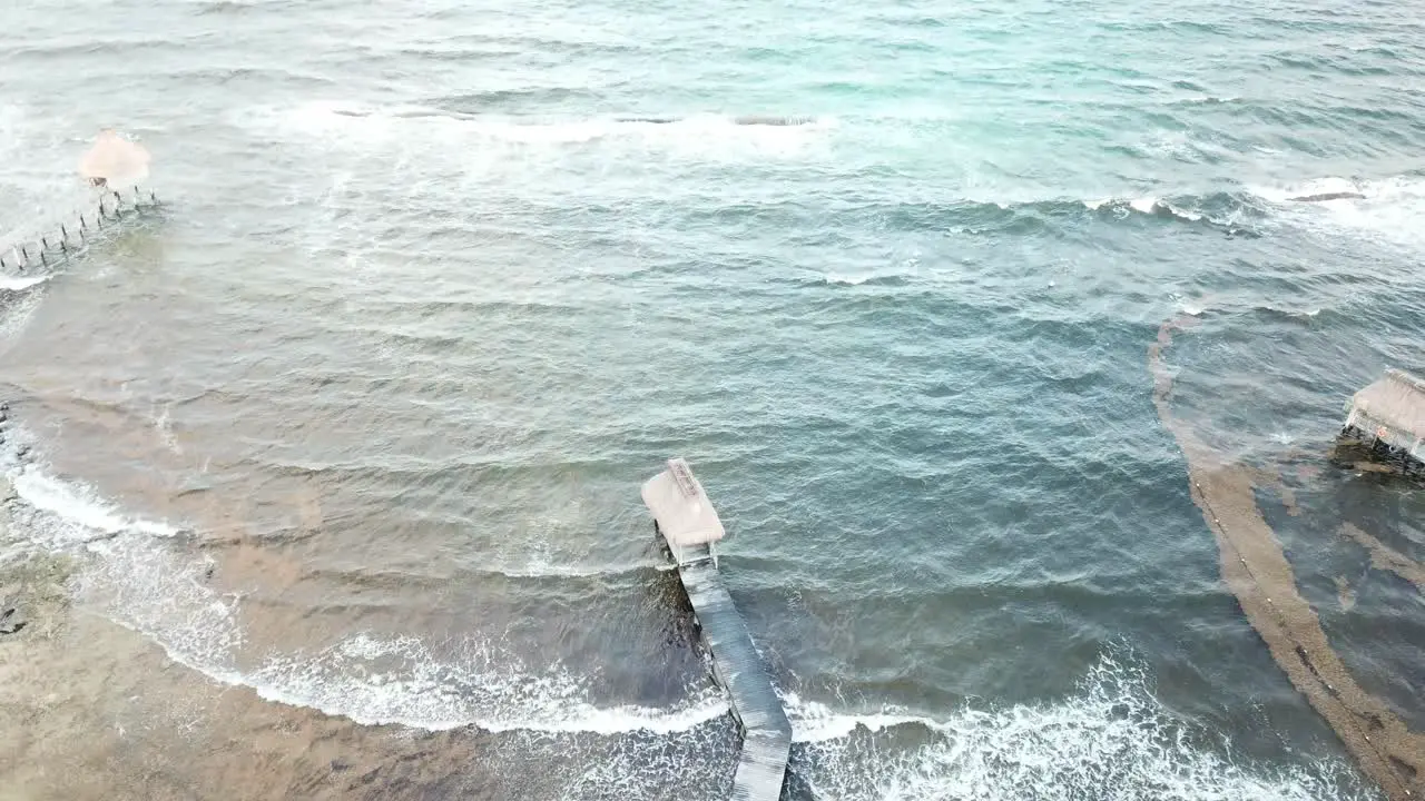 Waves Splashing At The Pier With Huts On The Caribbean Sea In Quintana Roo Mexico