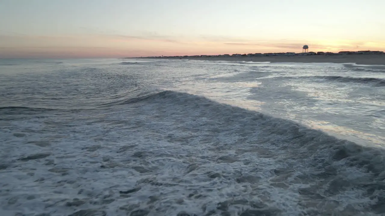 Waves And Ripples Of Sea Water Crashing Unto Distant Beach Aerial moving wide shot