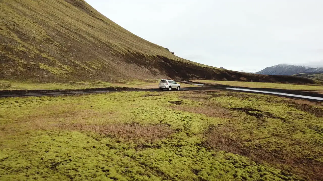 Four Wheel Crossover SUV on Urban Expedition in Iceland Rural Landscape Crossing Over Shallow River Tracking Aerial