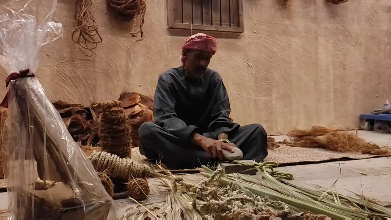 Fisherman making rope with dried palm leaves it is a traditional occupation in Arab countries and a part of arabic culture