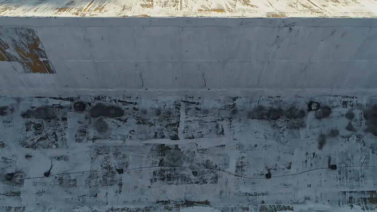 Aerial of rusty old factory roof with man in red shirt climbing on slope