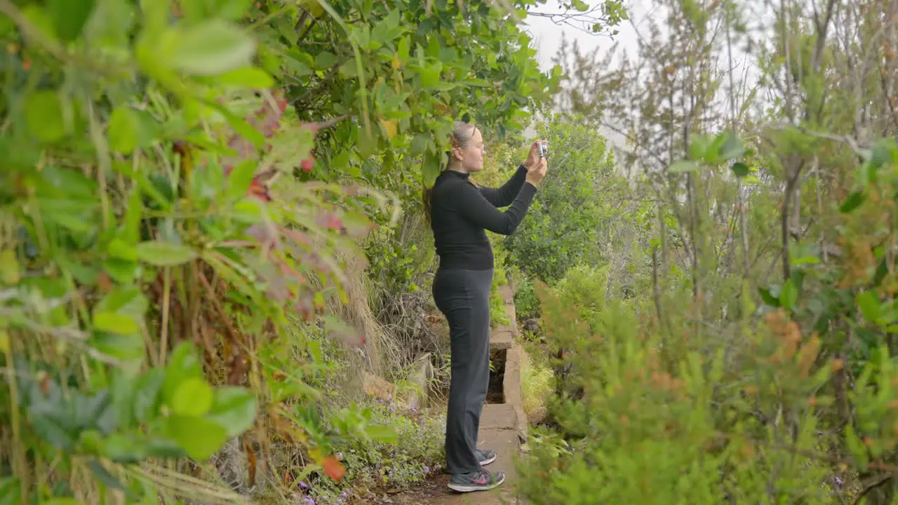 Young woman taking photos of Tenerife island nature handheld view