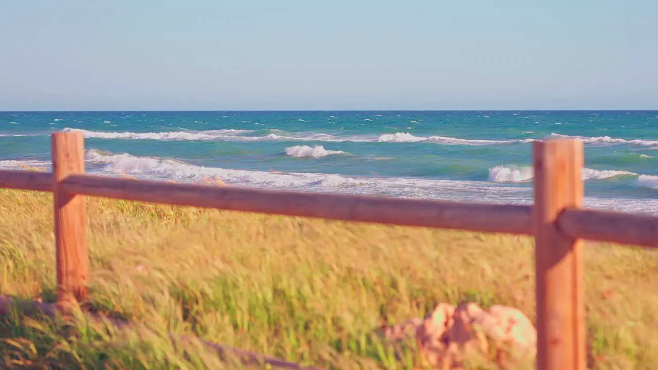 Ocean waves on a windy day with grass on the foreground out of focus