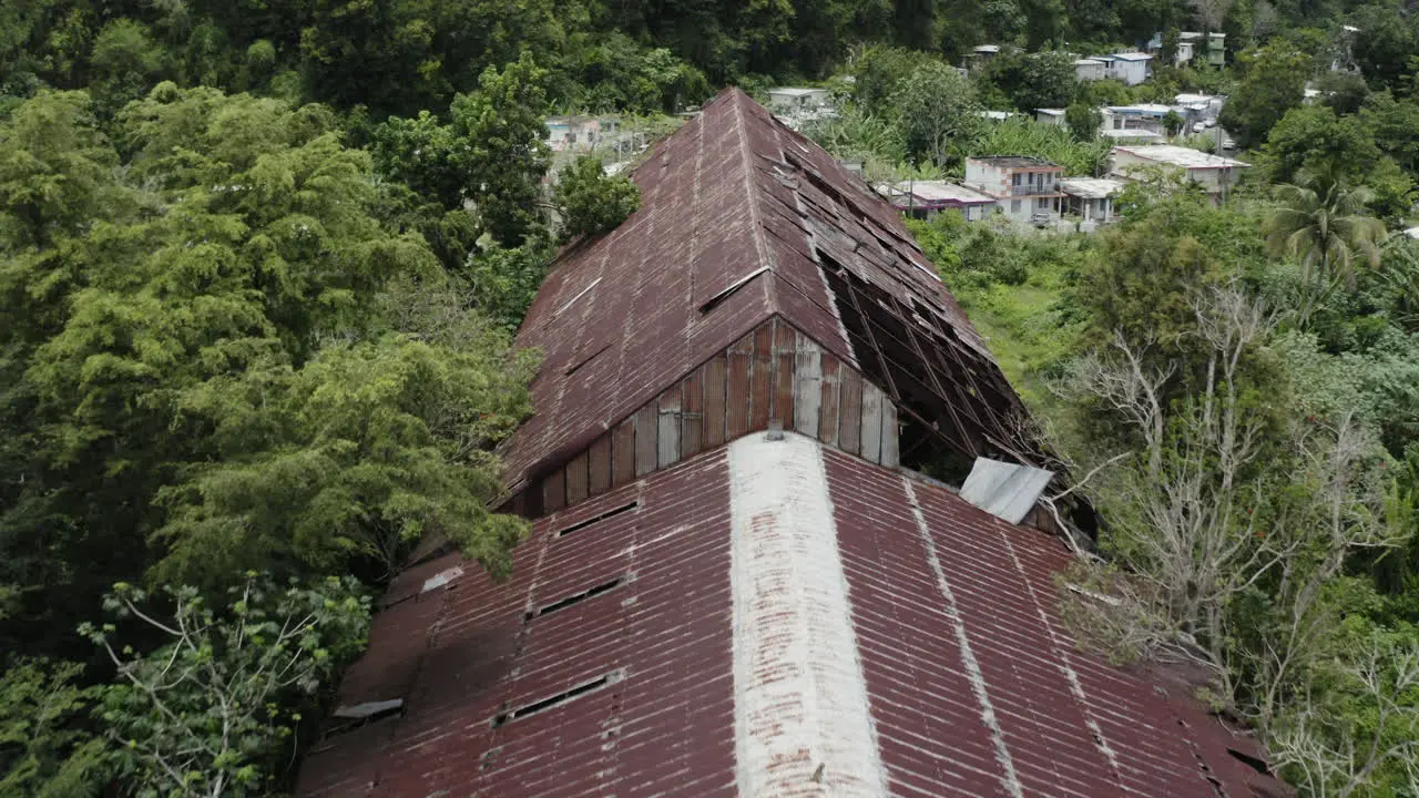 An abandoned and rusted old warehouse in Los Canos Puerto Rico has fallen into a state of disrepair and is slowly disappearing into the surrounding jungle