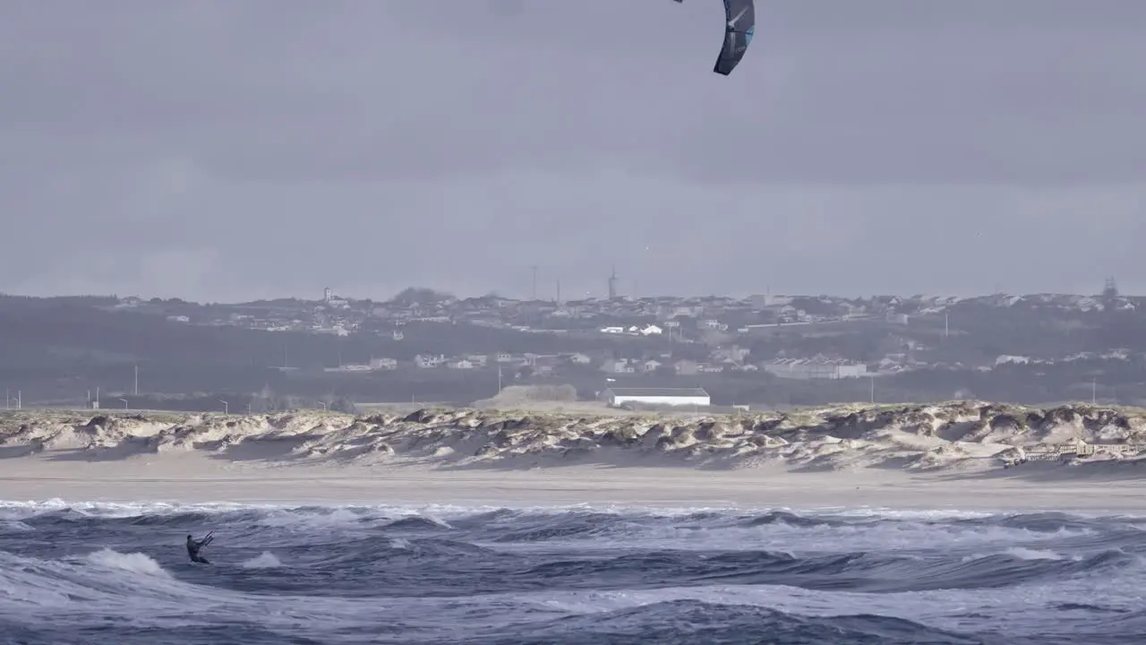 Kiteboarding or kitesurfing on rough ocean waves in Peniche Portugal one person view