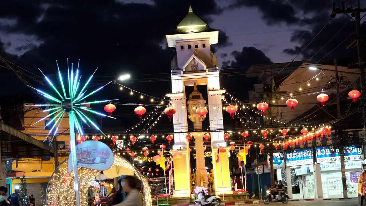 Night city lights with Chinese lanterns and people walking during Betong Festival in Thailand