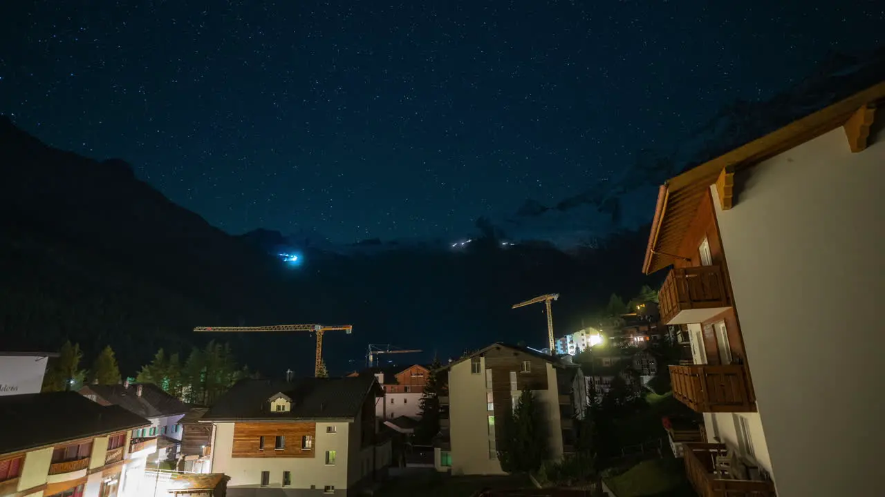 Saas Fee Village Switzerland Glacier cinematic time lapse Gletscher Swiss village clear deep blue night star sunrise transition morning mountain snow making cat track groomer lights up and down crane