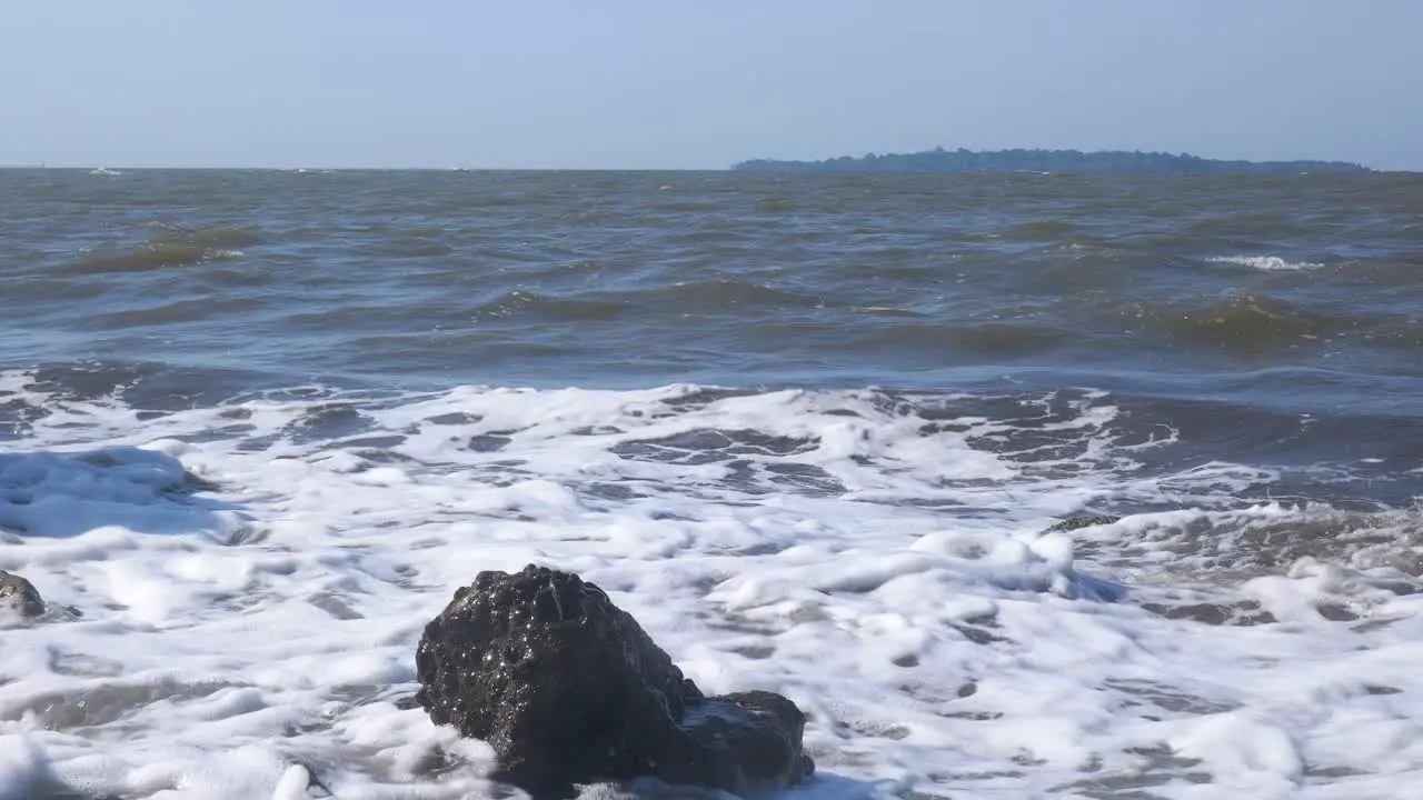 big waves hit the small rocks on the beach