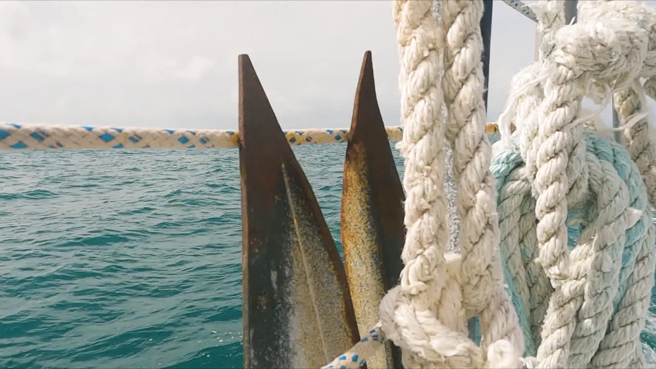 Closeup detail of anchor on board of moving sailboat sea scenery day