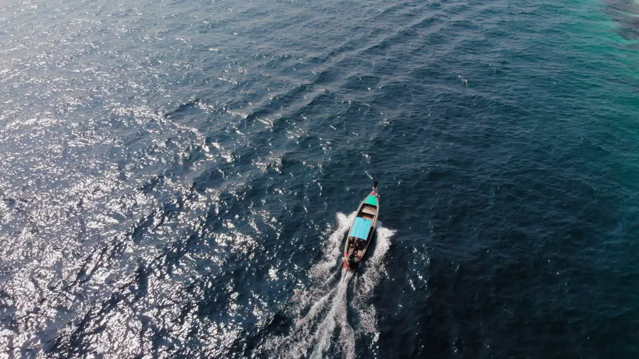 A Small Pump Boat Travelling Across The Deep Blue Green Coastal Waters In Thailand Mavic Drone Shot