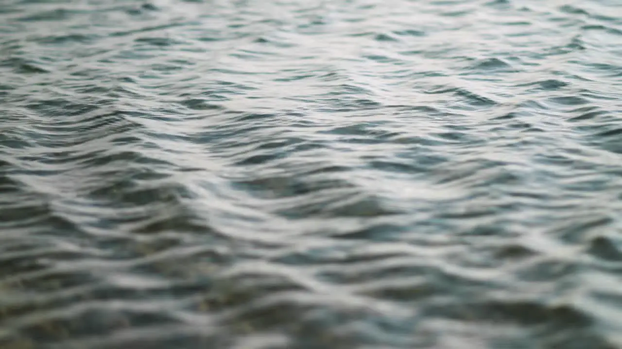 Gentle seaside waves rippling over shallow pebbles on beach