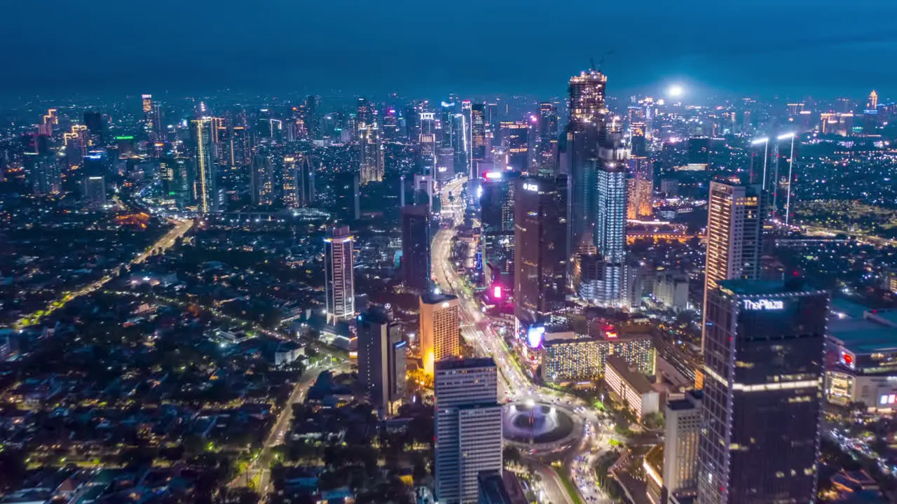 Stunning City View of Futuristic Skyline at Night Skyscrapers in Asian Indonesian Capital Jakarta with flashing lights and Car Traffic Flow on Main road Aerial Hyperlapse Time Lapse Drone View