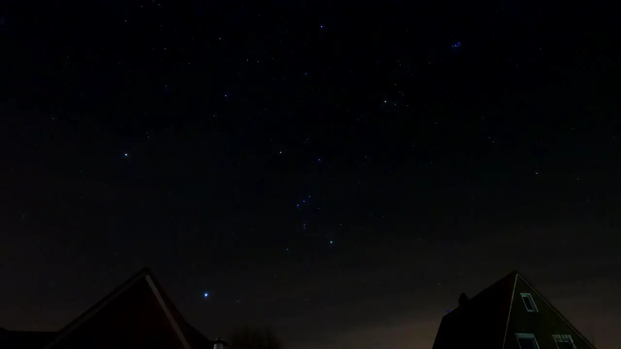 Star time lapse of the night sky moving above a house at midnight