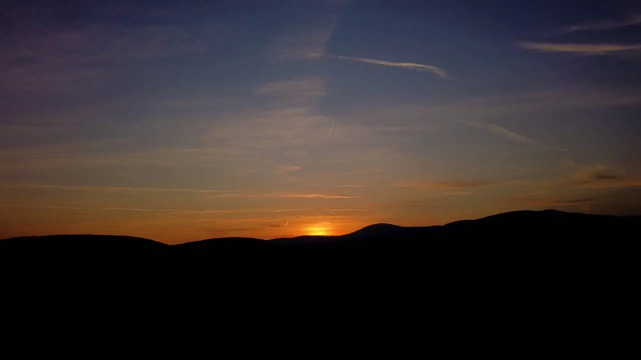 Sun slowly descending over hills in a timelapse