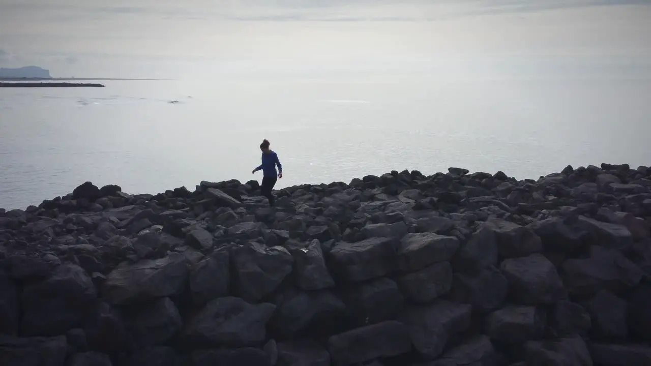 Girl Hiking Carefully On Black Volcanic Rocks In Ocean Background Black Beach Iceland