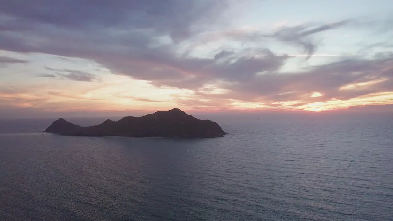 Beautiful view of small island in ocean at sunset