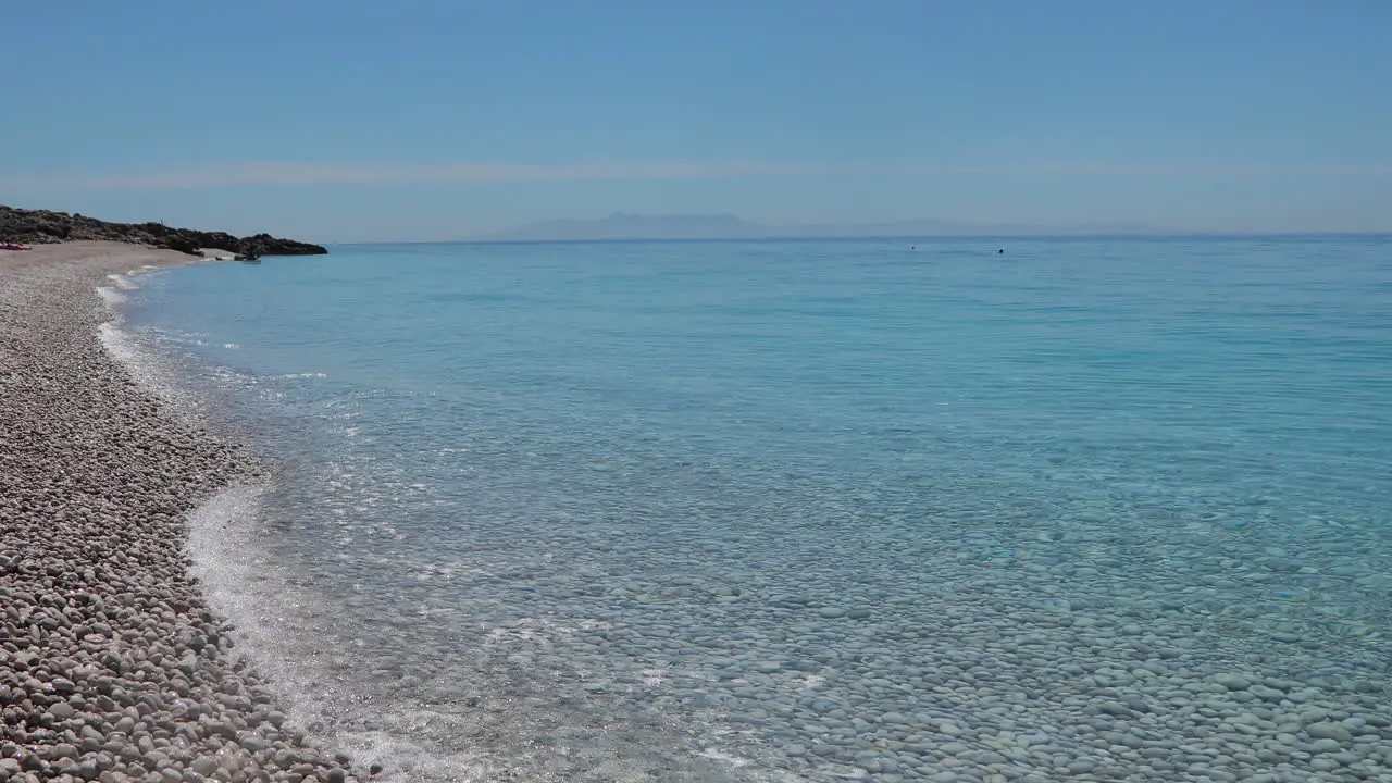 Clean sea water on peaceful shore of Mediterranean washing pebbles beach