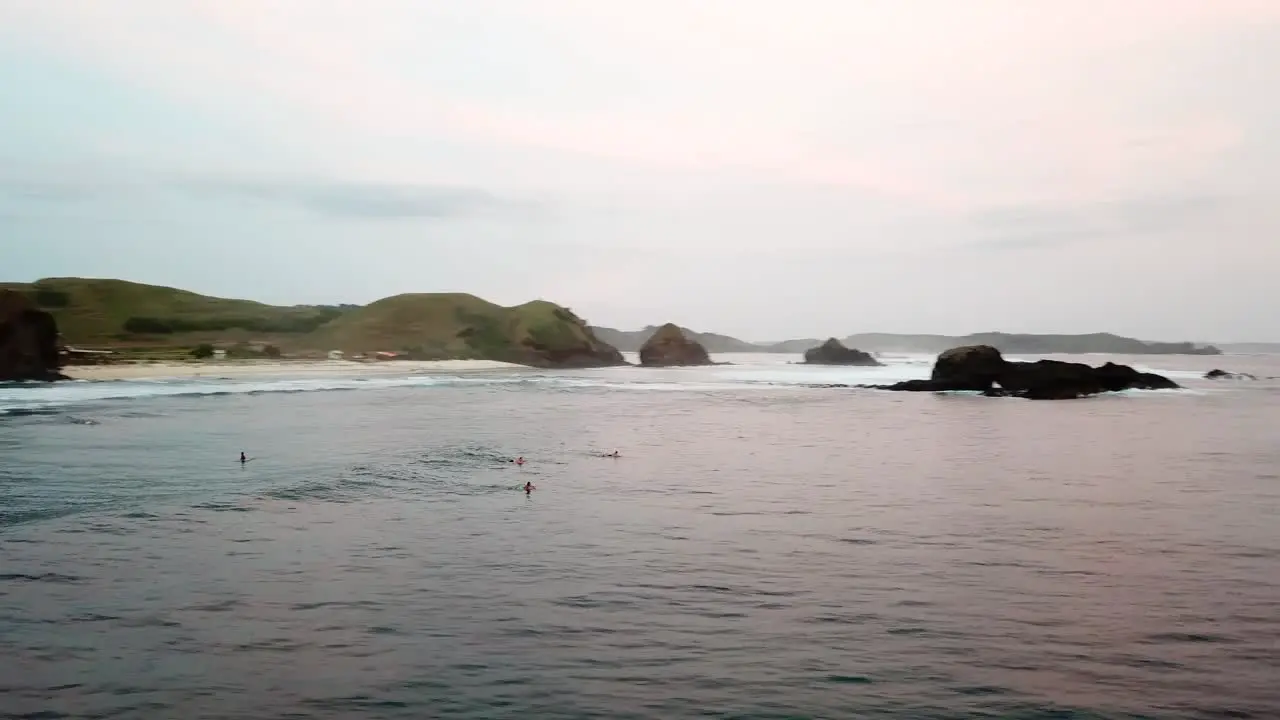 AERIAL 4K Panning Shot of Surfers Floating in Waters of Lombok Indonesia at Sunset 2