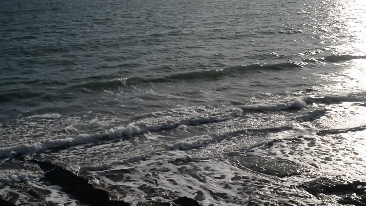 Small waves rolling ashore with majestic Rangitoto volcano in the background