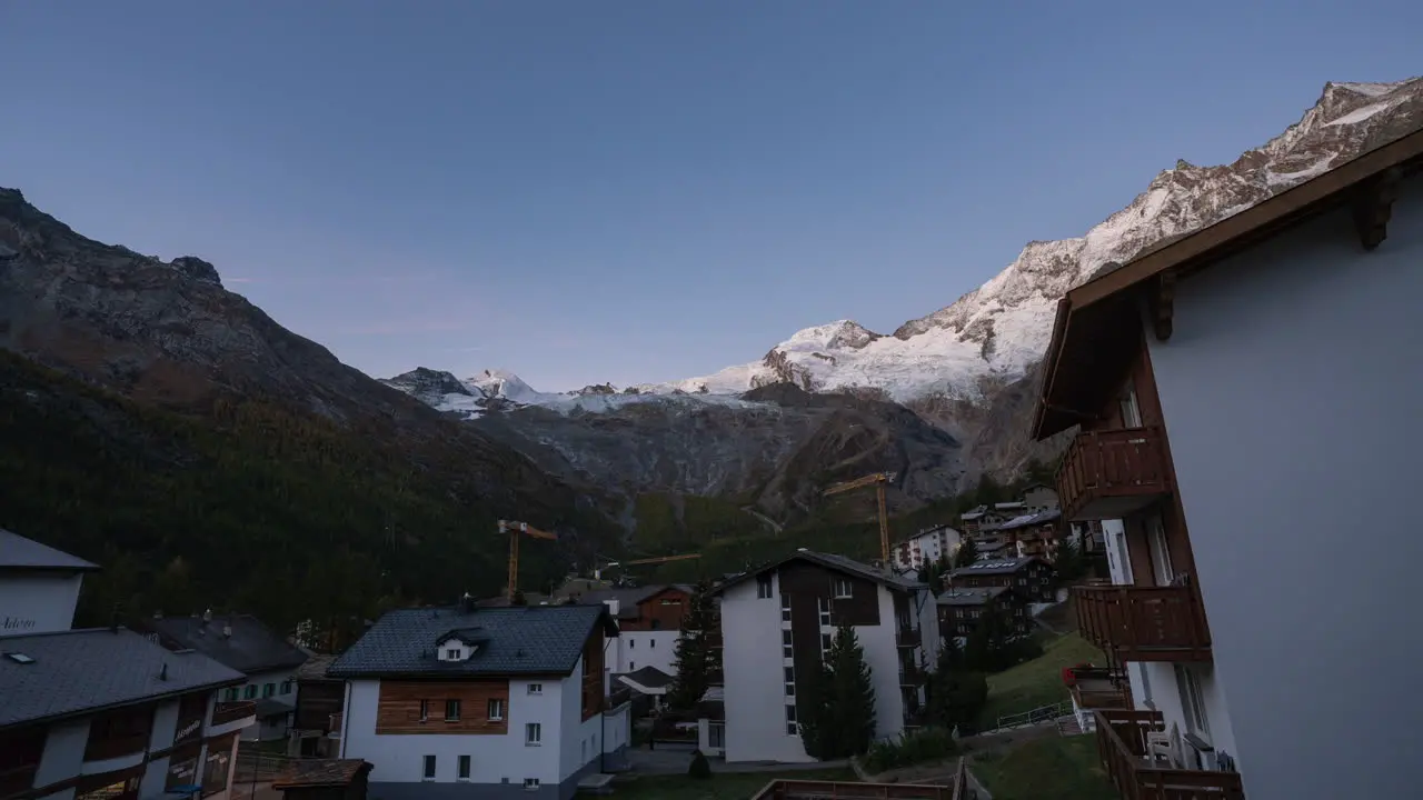 Saas Fee Village Switzerland Glacier Gletscher Swiss village clear sunrise morning cinematic time lapse cranes moving construction site zone mountain peaks lighting up with first light stunnning