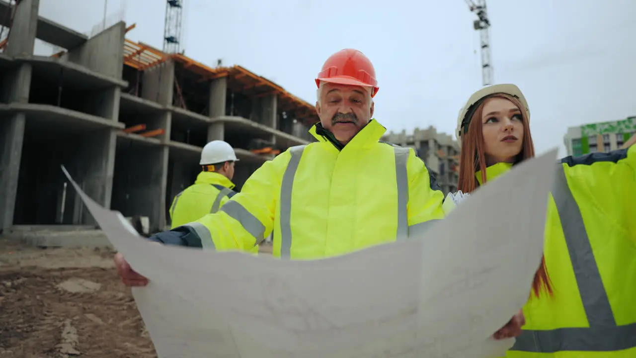 Dos Ingenieros Civiles Profesionales Están Discutiendo El Objeto De Construcción Un Capataz Anciano Y Una Mujer Joven