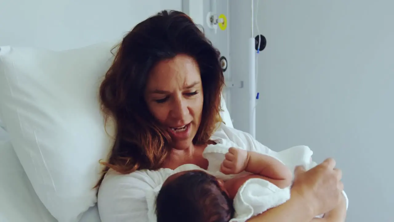 Vista Frontal De Una Madre Caucásica Sosteniendo A Su Bebé Recién Nacido En La Sala Del Hospital