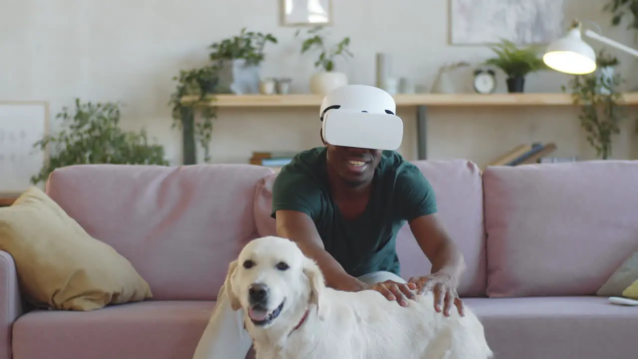 Hombre Negro Alegre Usando Auriculares Vr Y Tocando Perro En Casa