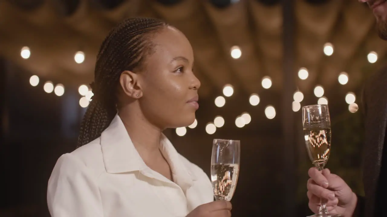 Man And Woman Holding Champagne Glasses And Talking To Each Other At New Year's Eve Party 2