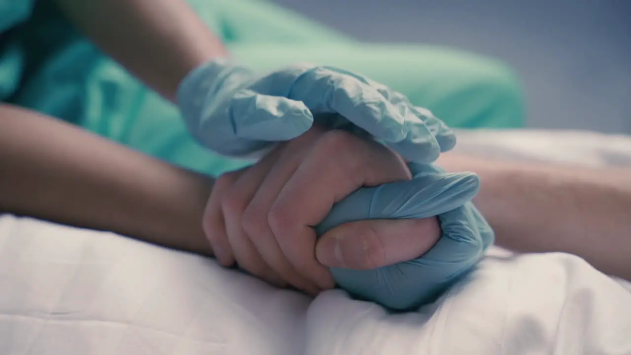 Detail Of A Nurse's Hands Grasping And Comforting The Hands Of A Sick Patient On Hospital Bed 1